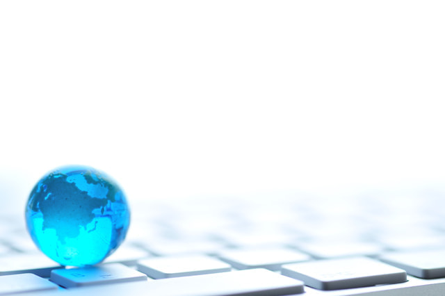 キ－ボ－ドの上に透明な青い地球儀